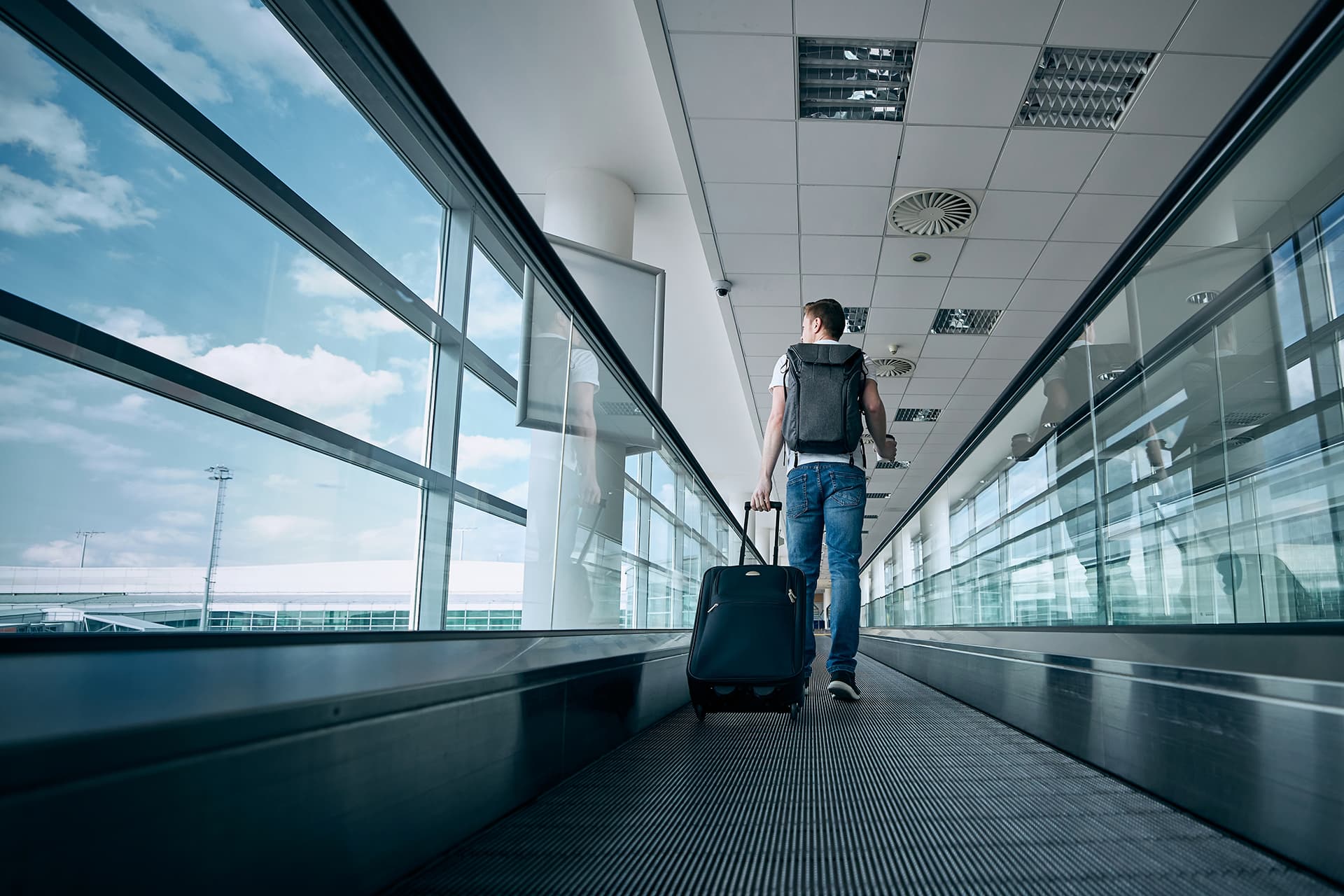 Traveler walking through an airport terminal with luggage